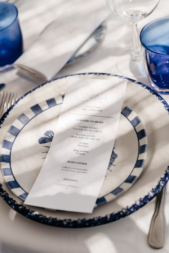 Menukaart op blauw-wit servies tijdens een bruiloftsdiner in Marbella – verzorgd door weddingplanner in Spanje