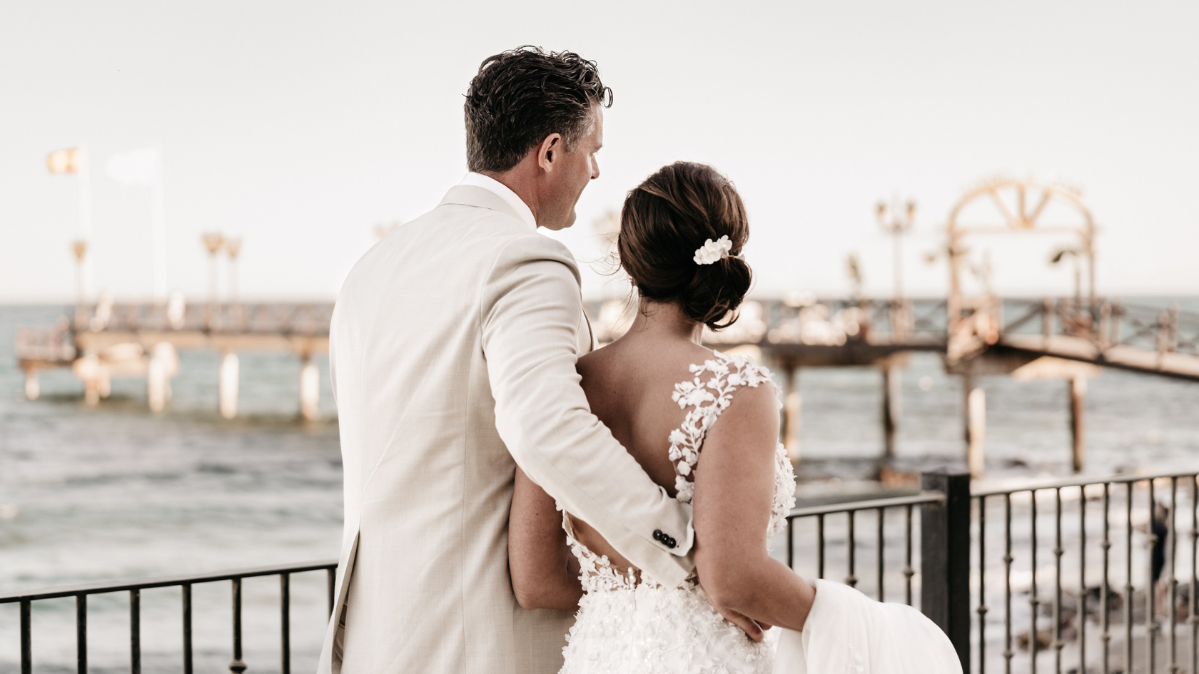 Bruidspaar Peter & Lotta loopt over de boulevard van Marbella langs de zee – een stijlvol moment tijdens hun luxe bruiloft, verzorgd door weddingplanner in Spanje